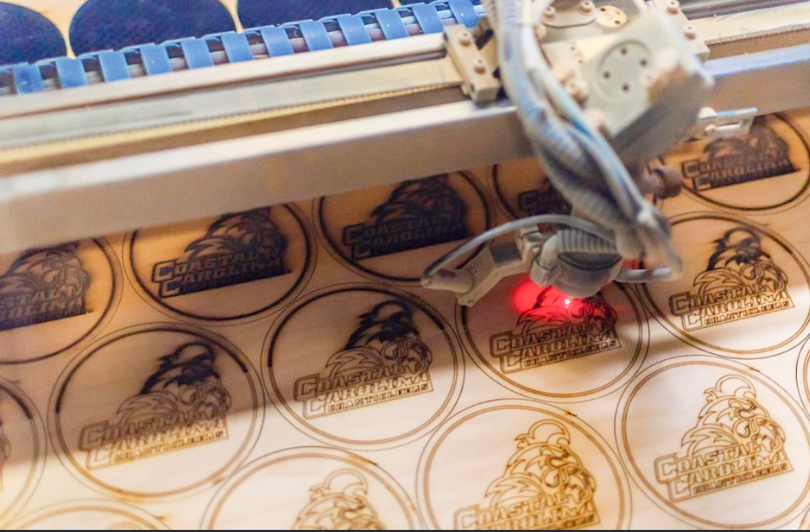 Laser machine cutting out a pallet of several coasters